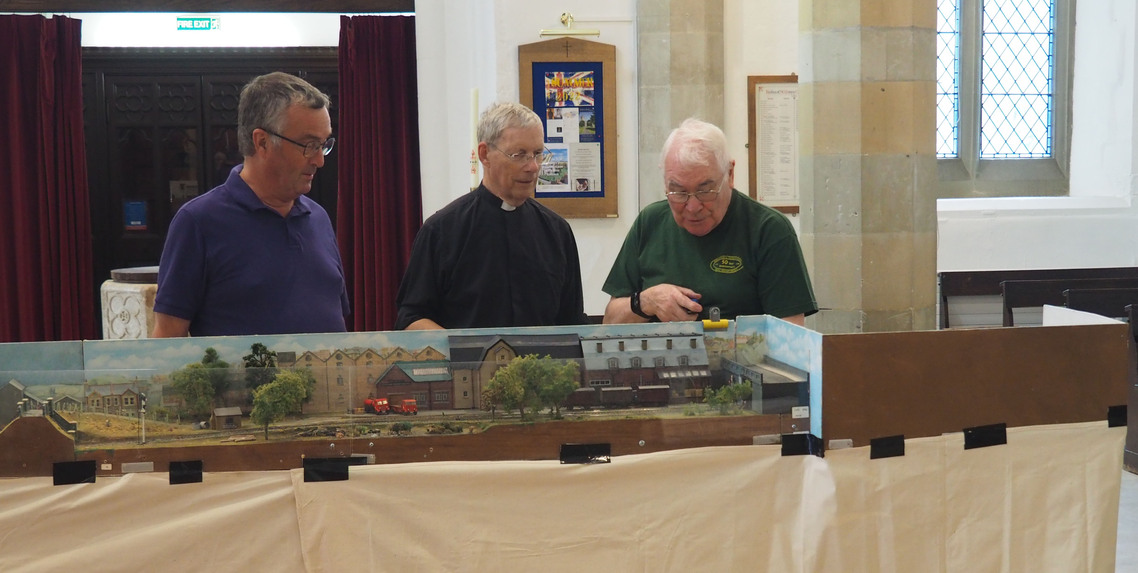 Three members of A&CMRS discuss running schedule in St Marys Church