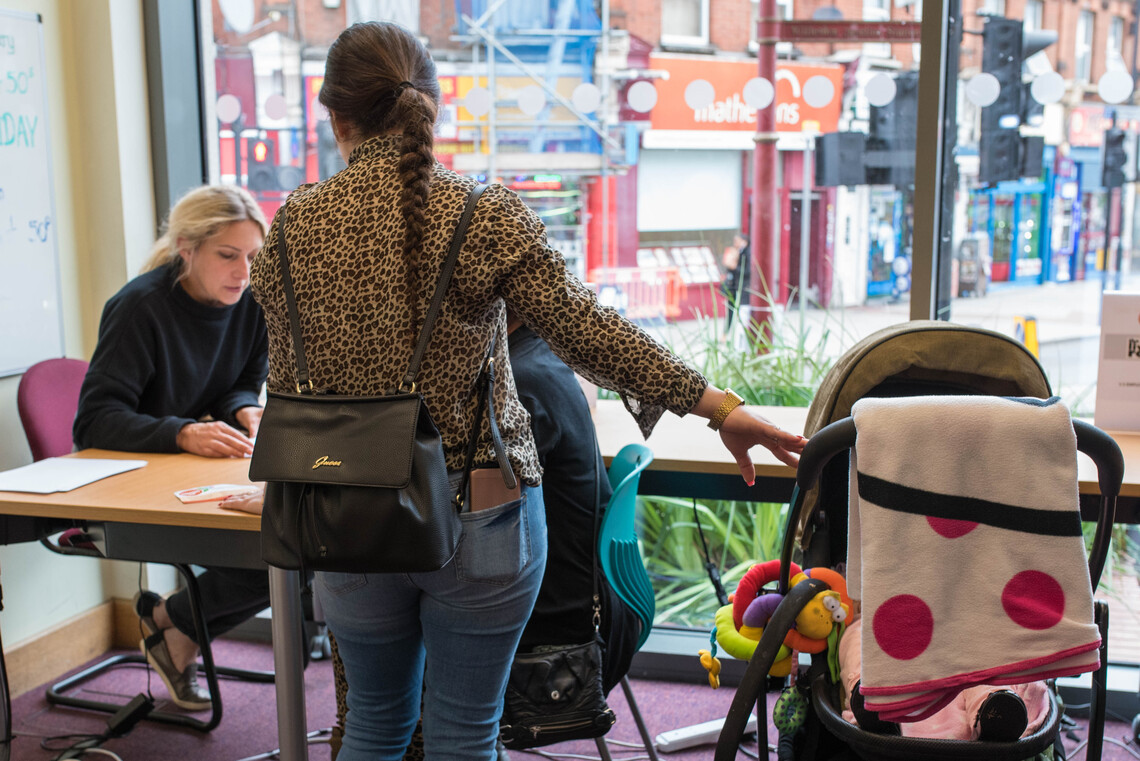 Adviser delivering service, two women and pushchair