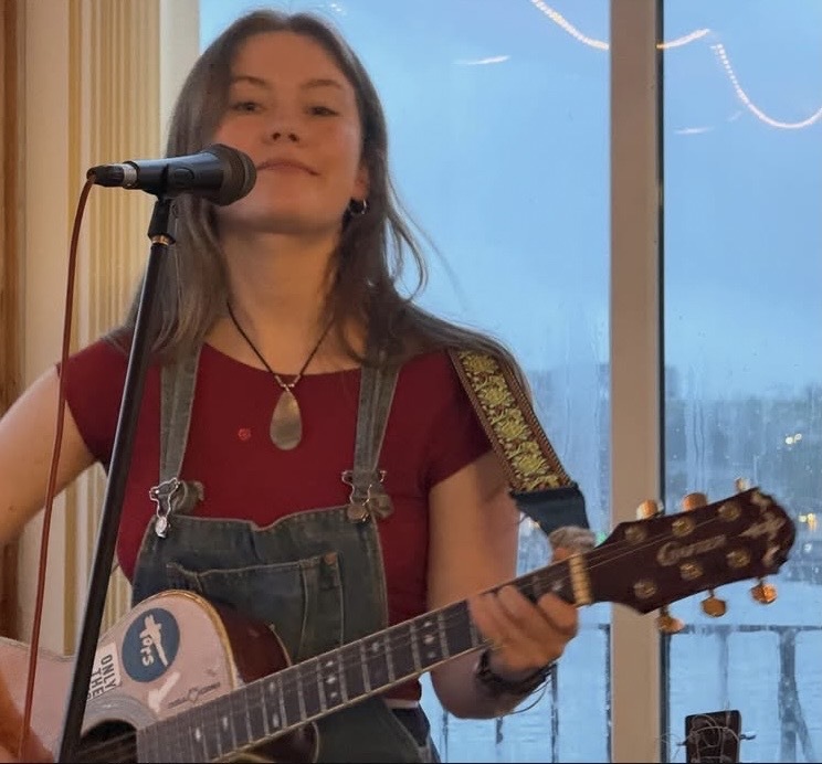 Charlotte Henry performing while playing guitar