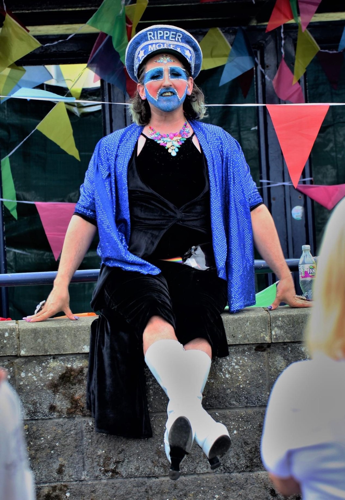Non-Binary performer Ripper Moff sits on the Promenade wall in Rothesay