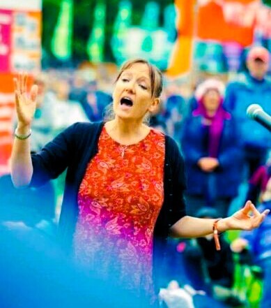White woman conductor against colourful background. Outdoor festival. 
