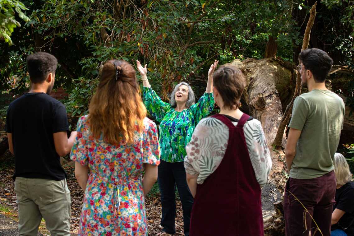 a group singing in nature infront of trees