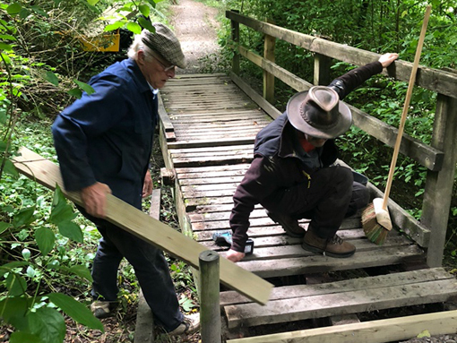 Voulunteers repairing bridge deck in Goat Field.