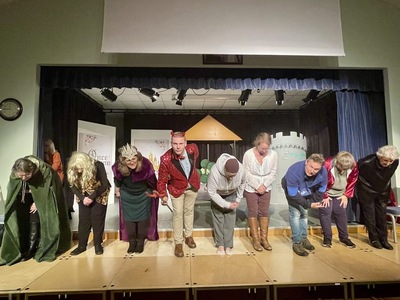The cast giving a bow at the end of the show in costume. 