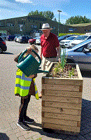 young volunteer watering herbs