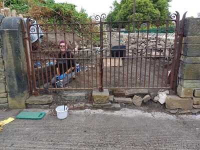 TASK6 - Volunteer Sue paints the rusty gates with protective black paint
