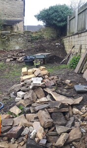 Dug up stone and a huge pile of soil and rubbish in the corner April 2023