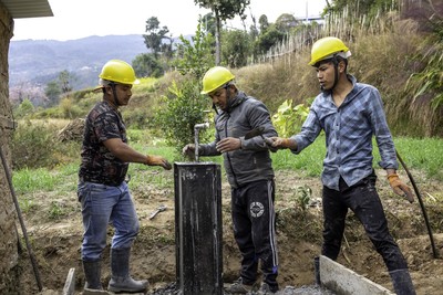 Community workers inspect a tapstand in Shailung