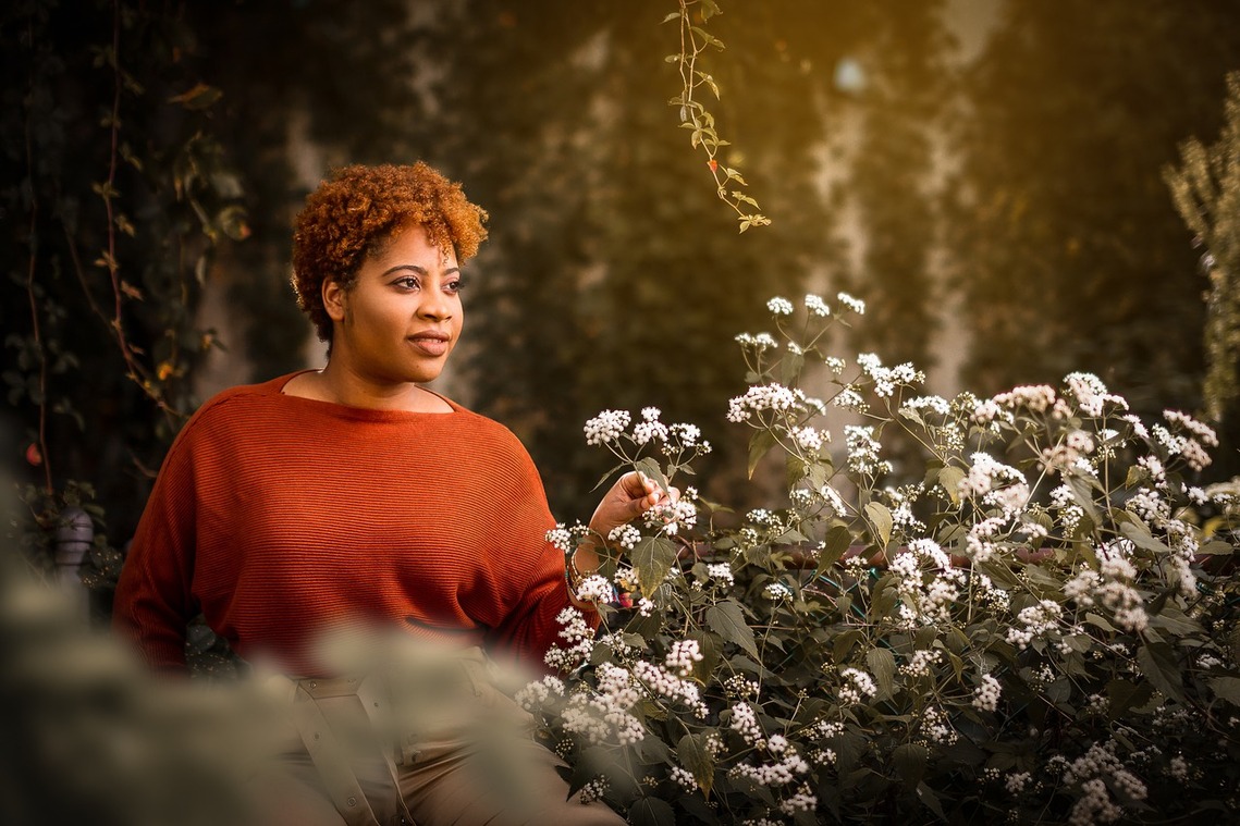 A mature Black woman in a woodland space