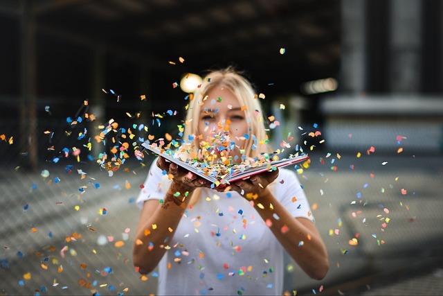 Woman Blowing Confettii off a book