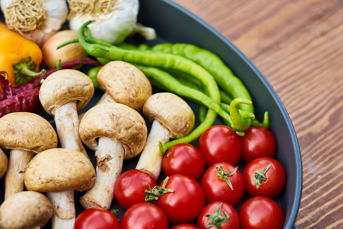 Mushrooms and peppers in close up on a chopping board