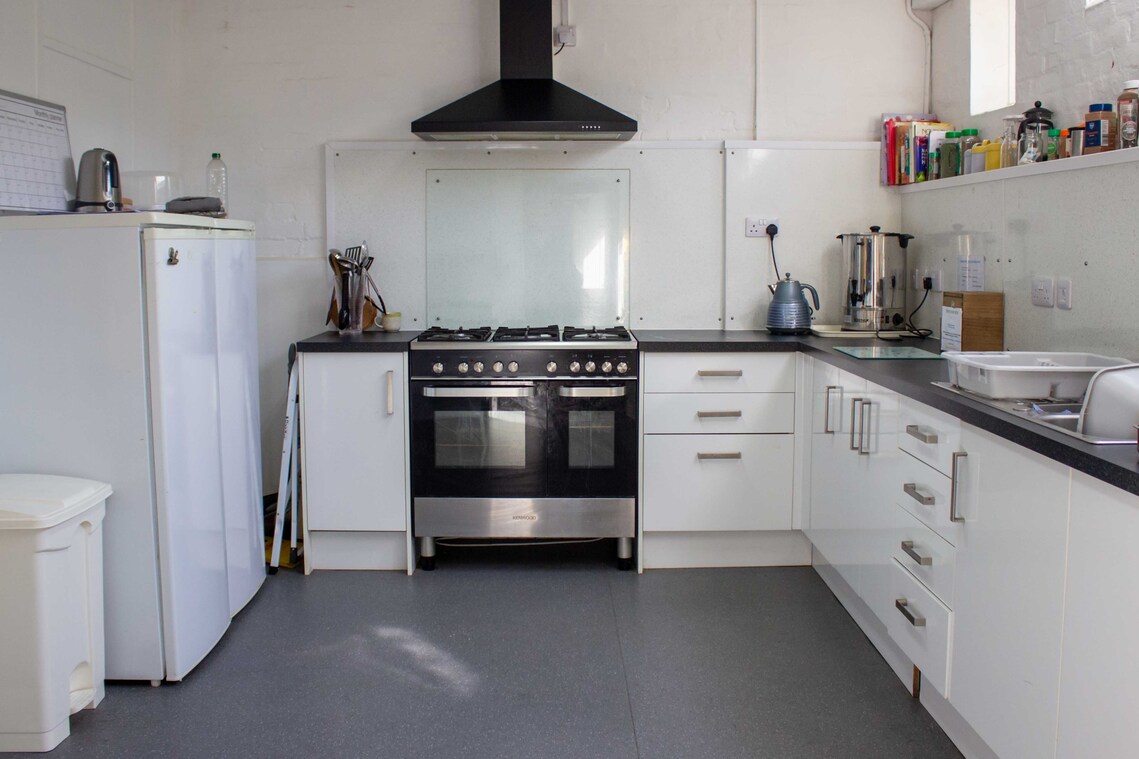A fully equipped kitchen, within the Buzzy-Bean Cafe with a counter.