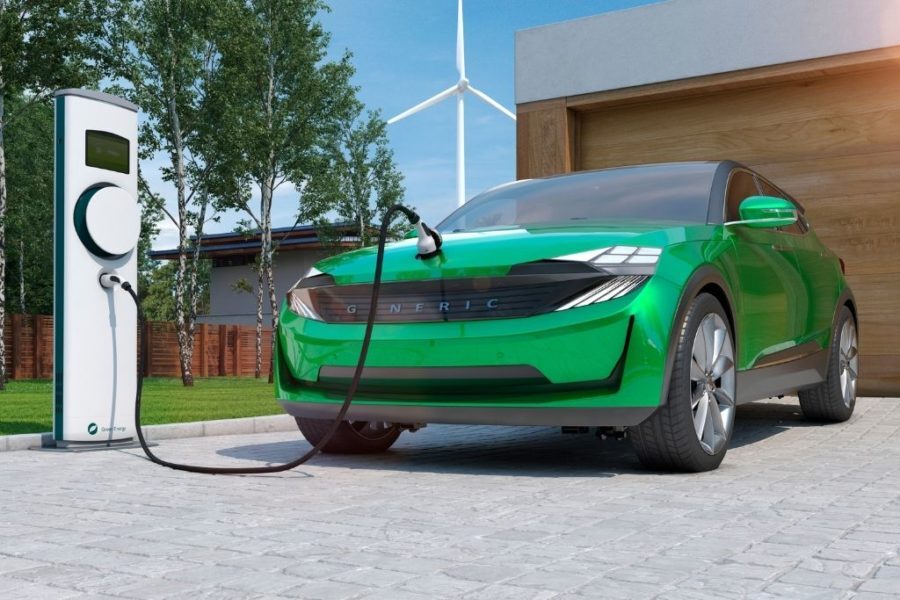Plugged in EV with wind turbine in background 