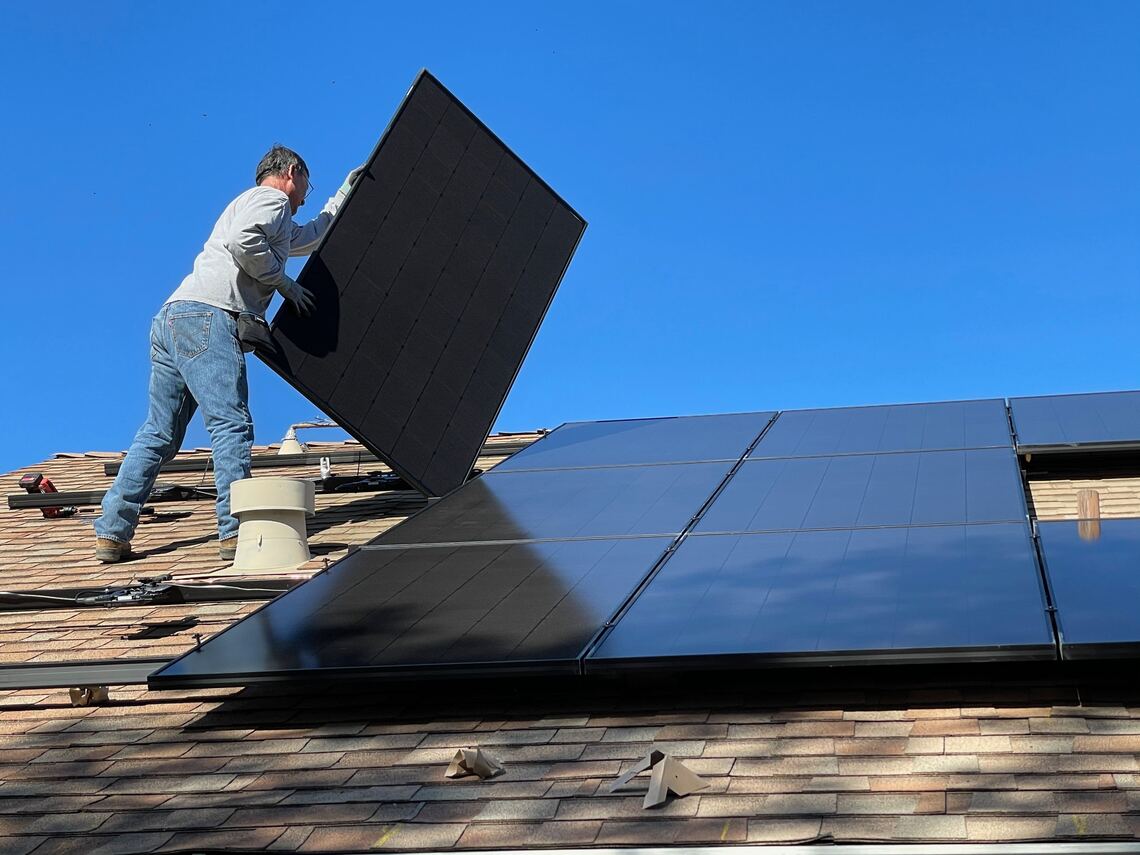 Fitter putting solar panels to roof