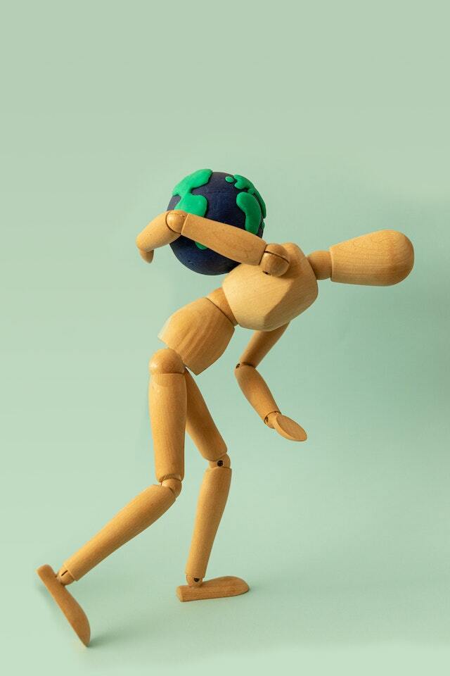 wooden human with world on their back