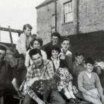 Harvest at Traine Farm, probably in August 1956. Fred Rowland (on the right) and Bob Penwill (left) are about to set out to collect the sacks of barley left in the field by the combine harvester.  There is no shortage of helpers.  Identified in the photograph are Susan, Jackie and Robert Rowland, Angela and Roger Grant, Adrian Pate and Keith Fretsome.