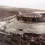 Bovisand beach in the early 20th century. A caf&eacute; stands in the left foreground. Bathers dot the beach. There are two rows of changing huts on the far side of the beach. And the conical tents are obviously a temporary camp. The seeds of Bovisand's present tourism were sown at this time.