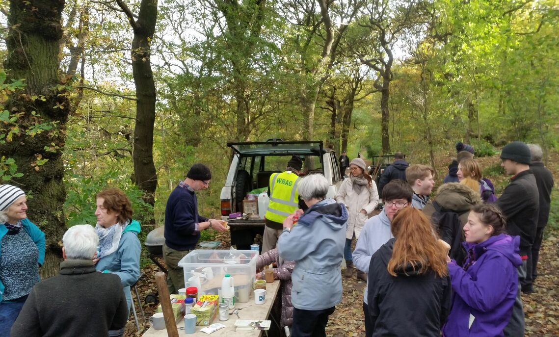 A group of volunteers of various ages having refreshments on the middle path